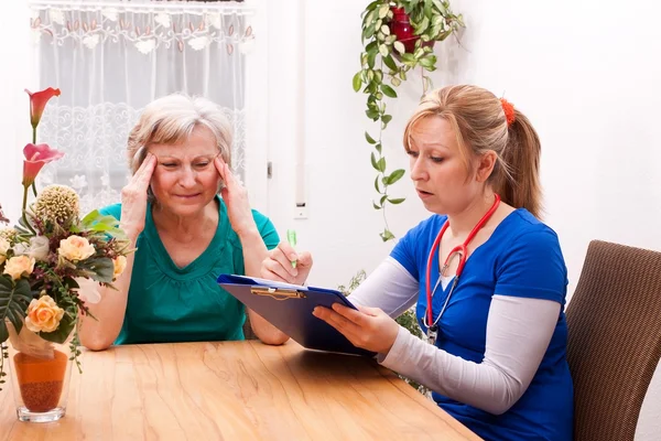 Nurse makes home visit and record data — Stockfoto