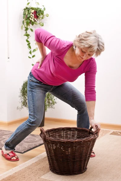 Senior has back pain due to heavy load — Stock Photo, Image