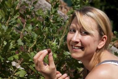 Pretty woman nibbles gooseberrys