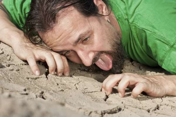 Thirsty man on parched soil — Stok fotoğraf