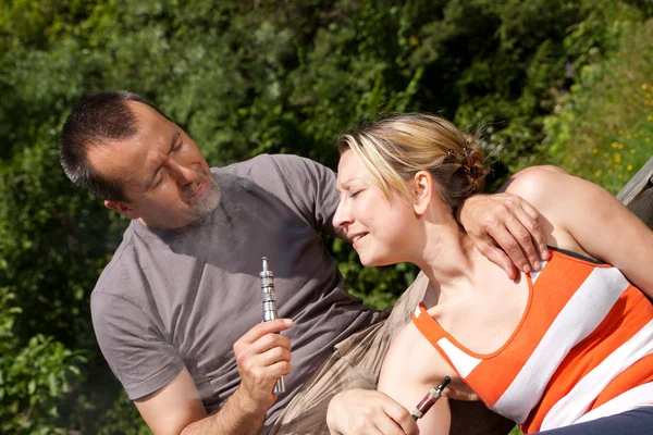 Couple with e-cigarette in nature — Stock Photo, Image