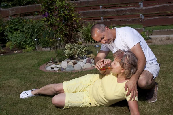 Man gives woman with heat exhaustion something to drink — Foto Stock