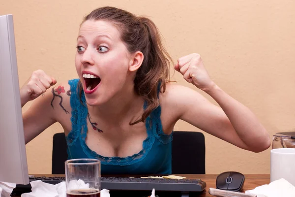 Young woman is jubilate in front of the monitor — kuvapankkivalokuva