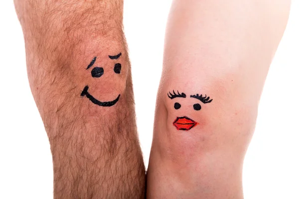 Two legs with faces, white background — Foto Stock