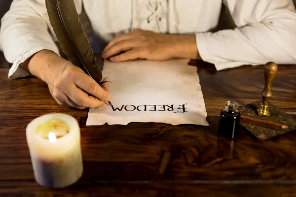 Man writes on parchment freedom — Stock Photo, Image