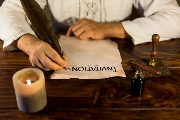 Man writing on a parchment Invitation — стоковое фото