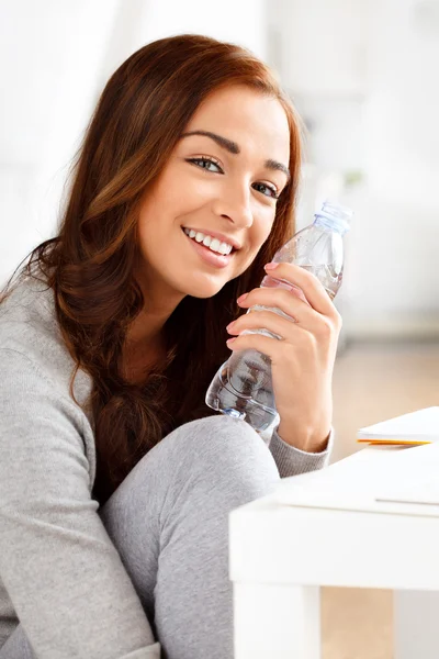 Bonita jovencita sosteniendo una botella de agua y sonriendo —  Fotos de Stock