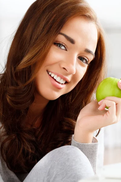 Mujer joven bastante saludable sonriendo sosteniendo una manzana verde —  Fotos de Stock