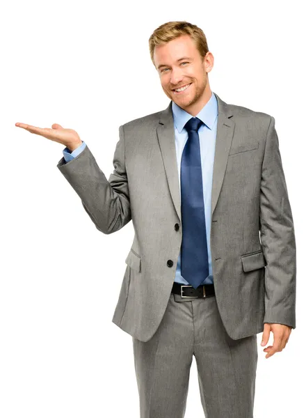 Счастливый молодой бизнесмен показывает пустое копирайт-пространство на белом бэкгро Стоковая Картинка