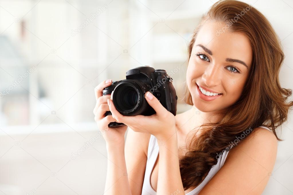 Pretty woman is a proffessional photographer with dslr camera