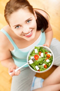 Attractive woman eating fruit salad