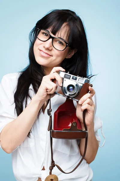 Linda joven fotógrafa sosteniendo cámara retro es un hipster — Foto de Stock