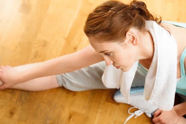 Gezonde jonge sportvrouw die zich uitstrekt in sportschool — Stockfoto