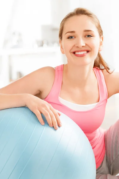 Retrato de atraente jovem mulher relaxante bola de fitness no ginásio — Fotografia de Stock