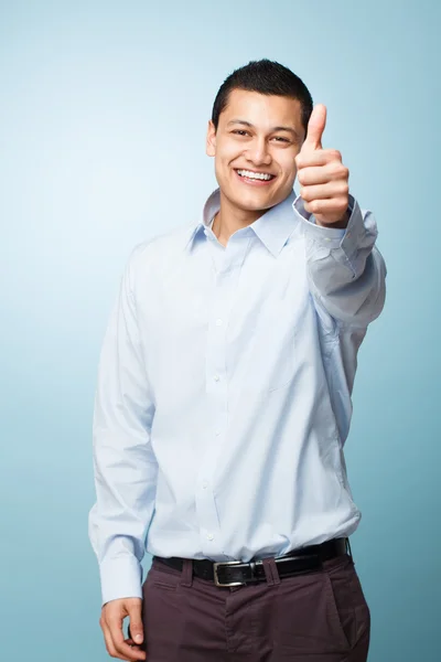 Happy young man giving thumbs up sign Stock Picture