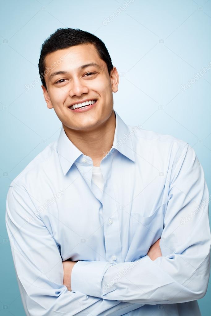 attractive confident young man smiling blue background