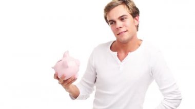 mutlu genç adam gülümsüyor ve parasını bir kumbara kaydetme