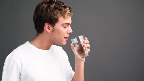 Gesunder junger Mann trinkt Glas Wasser — Stockvideo