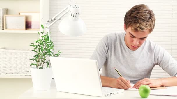 Heureux jeune étudiant étudie à la maison en préparation aux examens - à l'intérieur — Video