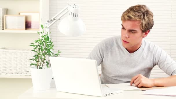 Giovane studente felice sta studiando a casa in preparazione per gli esami - al chiuso — Video Stock