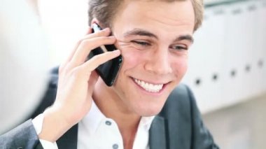 mutlu genç işadamı cep telefonu ofisinde konuşmak