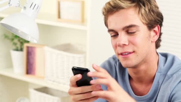Šťastný mladý muž pomocí mobilního telefonu textovou zprávu — Stock video
