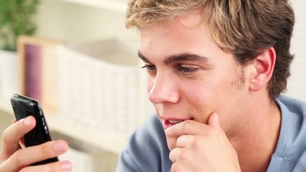 Joven feliz usando el teléfono móvil enviando mensaje de texto — Vídeos de Stock