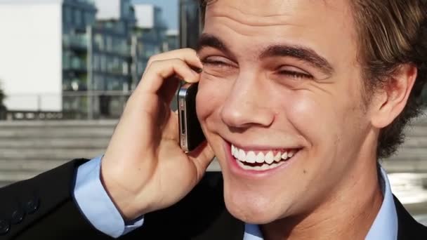 Happy businessman talking on mobile phone outdoors in the city — Stock Video