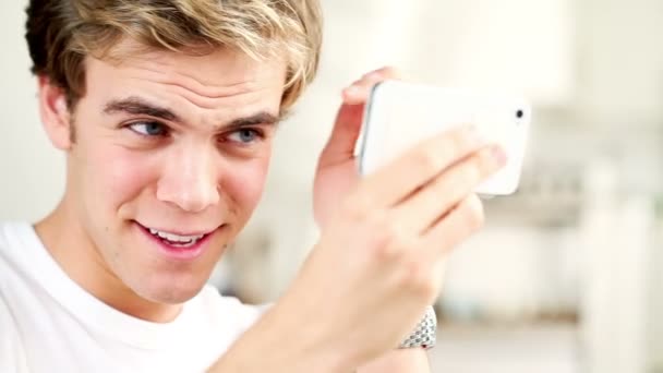 Prachtige kerel grooming zich met behulp van smartphone als een spiegel — Stockvideo