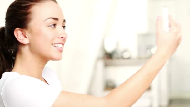 Menina engraçada tirando fotos de si mesma com telefone celular em casa — Vídeo de Stock