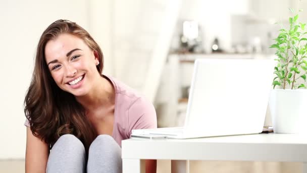 ホーム カメラ目線と笑みを浮かべて座っているきれいな若い女の子 — ストック動画