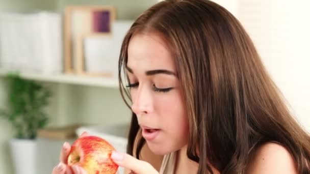 Lindo joven estudiante comiendo una manzana roja de cerca — Vídeo de stock