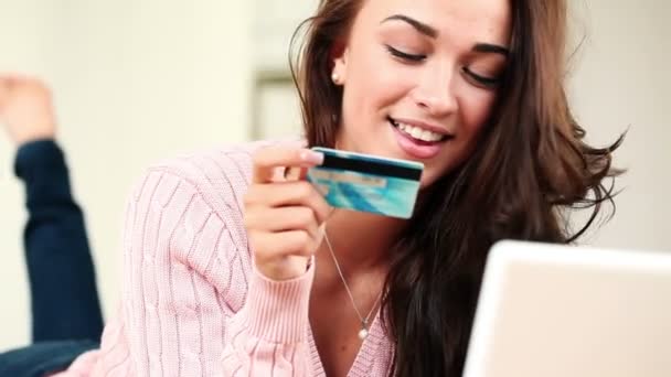 Pretty young teenage girl shopping online using her credit card and laptop computer — Stock Video