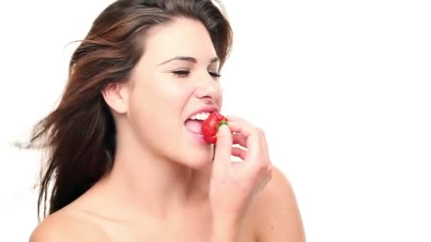 Hermosa mujer comiendo una fresa sobre fondo blanco — Vídeos de Stock