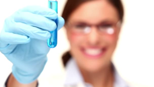 Smiling doctor holding the glass tube with blue liquid — Stock Video