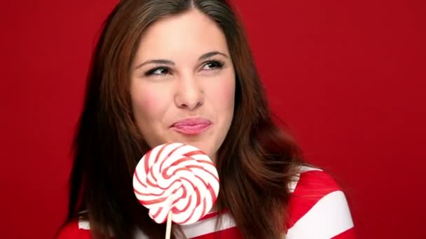 Attractive brunette girl holding a lollipop — Stock Video