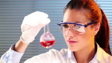 kadın bilimci Erlenmeyer flask kırmızı kimyasallar ile karıştırma