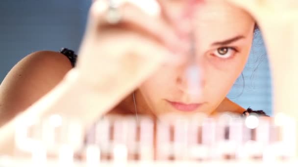 Chica joven usando una pipeta y tubos de ensayo en un laboratorio — Vídeos de Stock