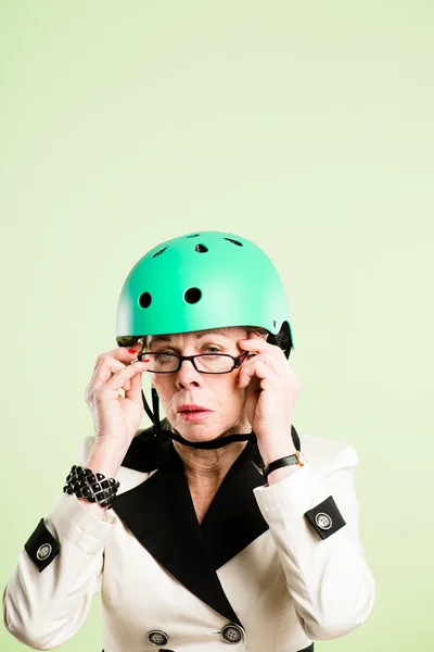 Mulher engraçada vestindo ciclismo capacete retrato rosa fundo real — Fotografia de Stock