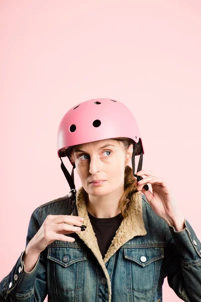 Mujer divertida con casco de ciclismo retrato rosa fondo real — Foto de Stock