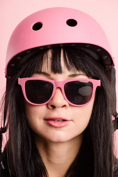 Mulher engraçada vestindo ciclismo capacete retrato rosa fundo — Fotografia de Stock