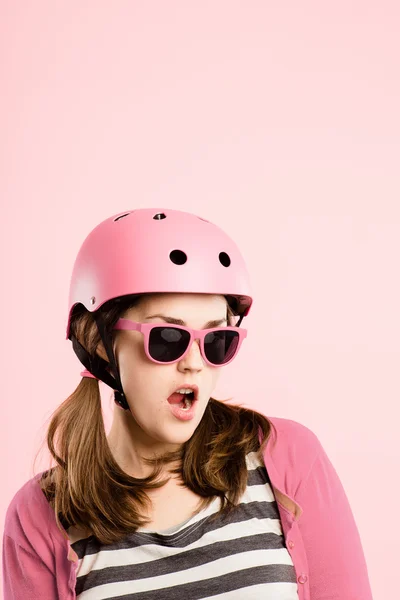 Mulher engraçada vestindo ciclismo capacete retrato rosa fundo — Fotografia de Stock