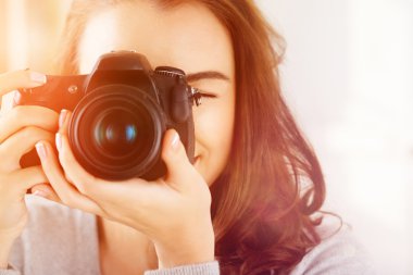 Pretty woman is a proffessional photographer with dslr camera clipart