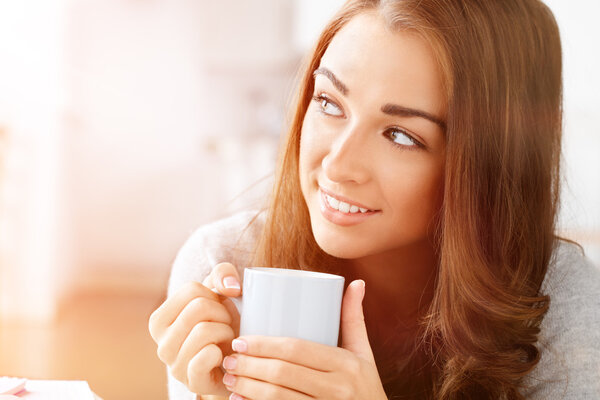 Attractive woman drinking coffee at home