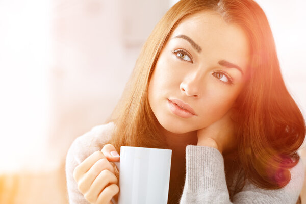 Attractive woman drinking coffee at home