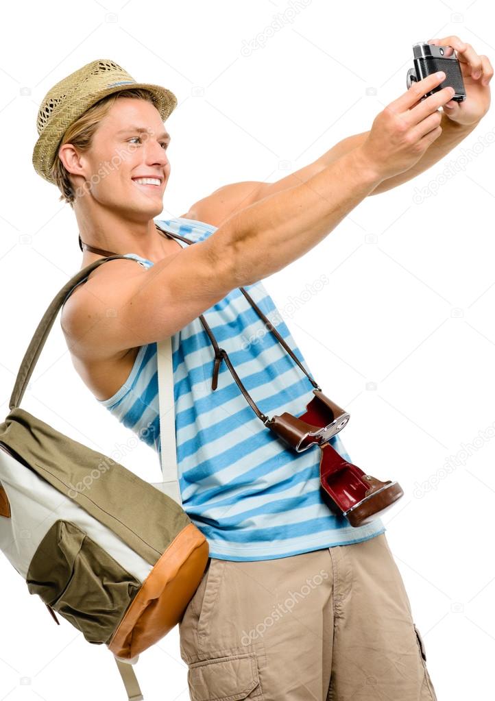 Happy tourist man photographing vintage camera isolated on white