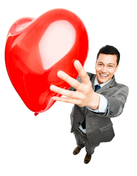 Homem de negócios segurando balão coração vermelho — Fotografia de Stock