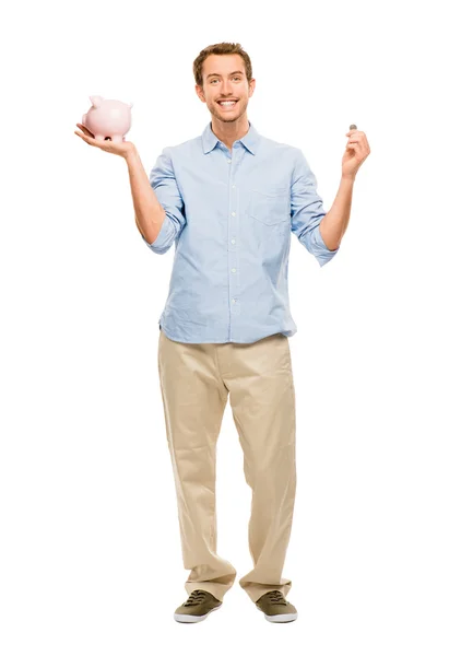 Happy young man putting money in piggy bank isolated on white — Stock Photo, Image