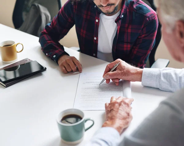 Financial Advisor Showing Student Where To Write Signature Holding Pen Young Man Applying For Loan Стоковое Фото