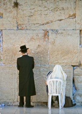 Two men praying in the wailing wall